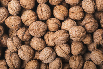 Background from fresh walnuts in the shell. Top view, flat lay.