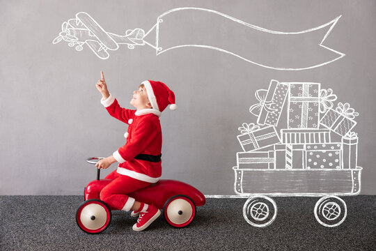 Happy child riding toy car. Christmas holiday concept