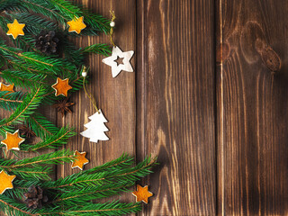 Wooden Christmas tree toys on a wooden background with fir branches. Festive background, Christmas.