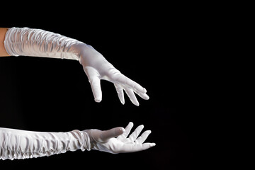 Hand gestures. Lady illusionist, beautiful hands in long white gloves make a spell. Shows and...