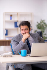 Young male employee looking after new born at workplace