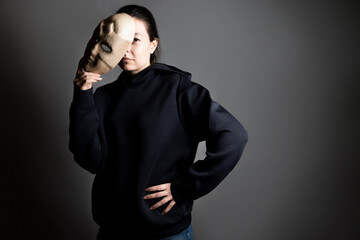 Remove the mask, reveal the identity, express yourself in something, the concept. A young woman in...