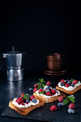 Bruschetta with cheese, jam and fresh raspberries and blueberries