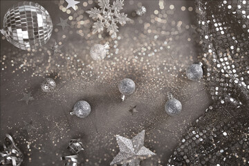 Christmas decoration with silver toys, stars, balls on gray background. Top view