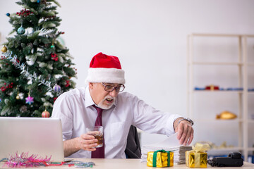 Aged male employee celebrating Christmas at workplace