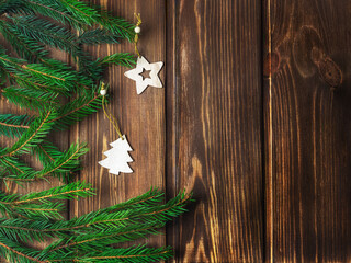Wooden Christmas tree toys on a wooden background with fir branches. Festive background, Christmas.