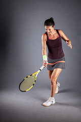 Professional female tennis player. Girl swinging racket.