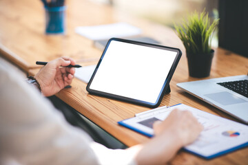 hand image of a male freelancer holding a blank screen tablet in his modern workplace