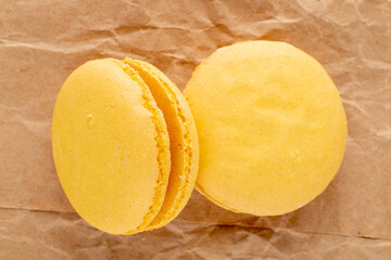 Two sweet macaroons on craft paper, close-up, top view.