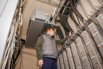 Servicing the Automatic Telephone Station in the server room. The technician is laying...