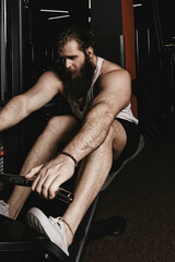 Fototapeta na wymiar Bearded strong man working out in gym doing exercise for back. 