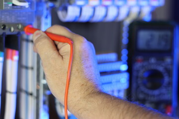 An electrical engineer measures the parameters of electrical circuits using a multimeter in the...