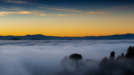 hilly mountain landscape with fog at dawn