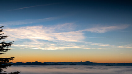 hilly mountain landscape with fog at dawn