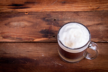 Cafe latte coffee in a glass coffee cup on a wooden background