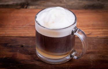 Cafe latte coffee in a glass coffee cup on a wooden background
