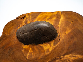 Round smooth stone inside wooden cut