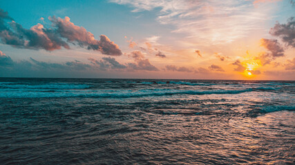 Piękny widok zachodzącego słońca, na tle fal i oceanu.  - obrazy, fototapety, plakaty