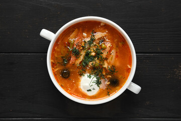 Overhead view of cabbage soup with sausage and olives