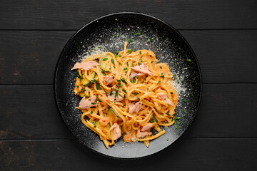 Overhead view of pasta with salmon and zuccini with grated parmesan