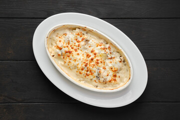 Overhead view of potato and hamboletus baked in oven with cheese and bacon