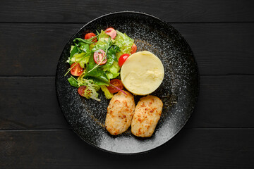 Overhead view of meat cutlet with mashed potato and fresh vegetables