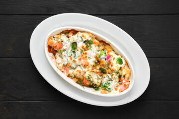 Potato and ham baked in oven with cheese and vegetables