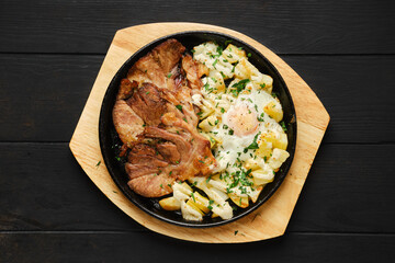 Overhead view of fried pork t-bone chop with potato and egg