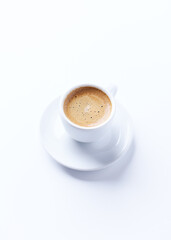 Cup of coffee on bright paper background. Copy space.