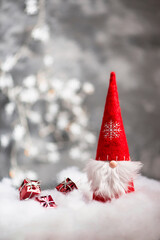 Christmas gnome greeting card with bokeh fairy lights and snow, winter season, gift on the sledge