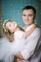 Dad and daughter. Dad kisses daughter. Dad holds little daughter in his arms. Portrait of a father and daughter. Smiling baby and her dad.