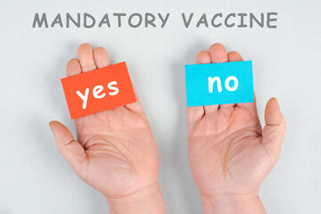 Mandatory vaccination, yes and no is standing on paper, making a decision, covid-19