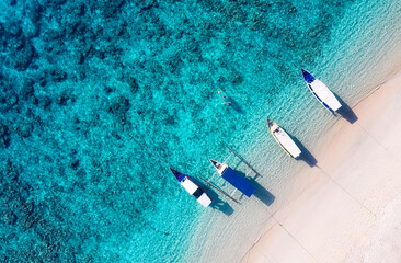 Boot in Strandnähe. Hintergrund des blauen Wassers von der Draufsicht. Sommermeerblick aus der Luft. Luftlandschaft. Reisebild
