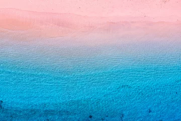 Foto op Plexiglas Luchtfoto strand Roze strand en oceaan als achtergrond van bovenaanzicht. Blauwe waterachtergrond van drone. Zomer zeegezicht vanuit de lucht. Afbeelding voor reizen en vakantie