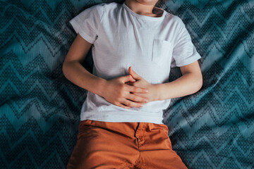 abdominal pain in a preschool child. poisoning in children. the boy holds his hands to the...