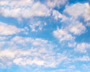 Naklejka na ściany i meble Blue sky set against dreamy clouds with slight iridescence