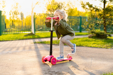 Little blonde girl on a scooter near school © Надежда Урюпина