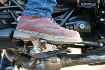 Close-up of the foot in shoes on a motorbike