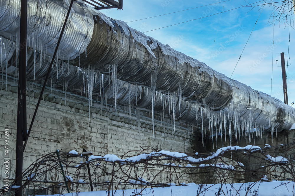 Wall mural ice icicles on a metal pipe of an industrial pipeline. industrial equipment. gas pipeline. north. fl