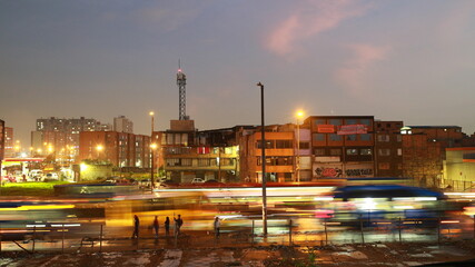 Fototapeta premium Avenida en Bogotá y viviendas, personas y autos en movimiento.