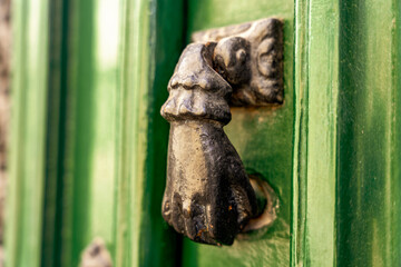 Kołatka w kształcie ręki, stara, ozdobna montowana na drzwiach. - obrazy, fototapety, plakaty