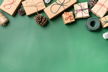 Set of Christmas gift boxes in craft paper with natural decorations on trendy dark green background. Eco friendly zero waste Christmas concept. Plastic free holidays. Copy space for your text.