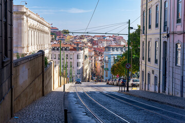 Krajobraz miejski, ciasne uliczki, tramwaje i tory tramwajowe w mieście Lizbona, Portugalia.