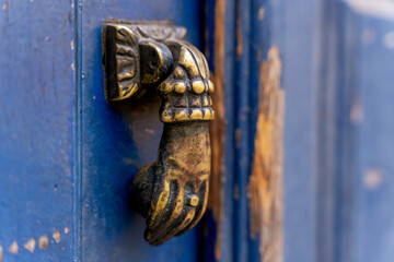 Kołatka w kształcie ręki, stara, ozdobna montowana na drzwiach. - obrazy, fototapety, plakaty