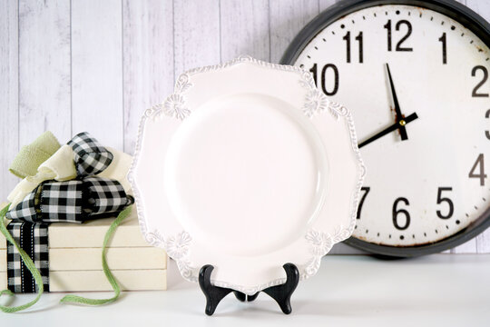Vintage plate product mockup. New Year's Eve farmhouse theme SVG craft product mockup styled with large rustic clock, stack of books and buffalo plaid ribbon agasint a white wood background.