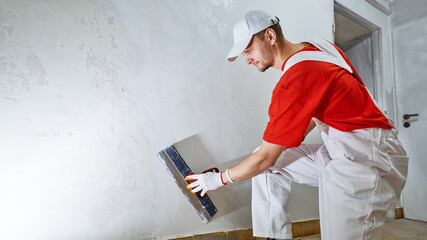 Plasterwork and wall painting preparation. craftsman applying plaster or filling