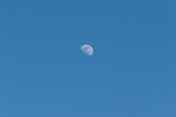 Crescent moon on a blue sky day in Madrid, Spain