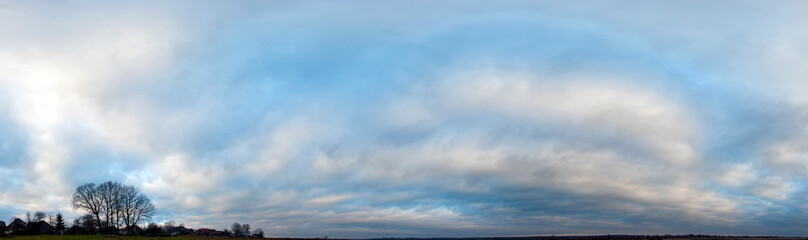 Panorama of sunny and stormy sky on a background of mountains
