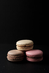 Three macarons with black background below