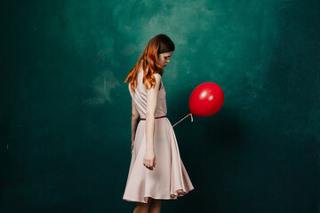 pretty woman in dress red balloon birthday green background